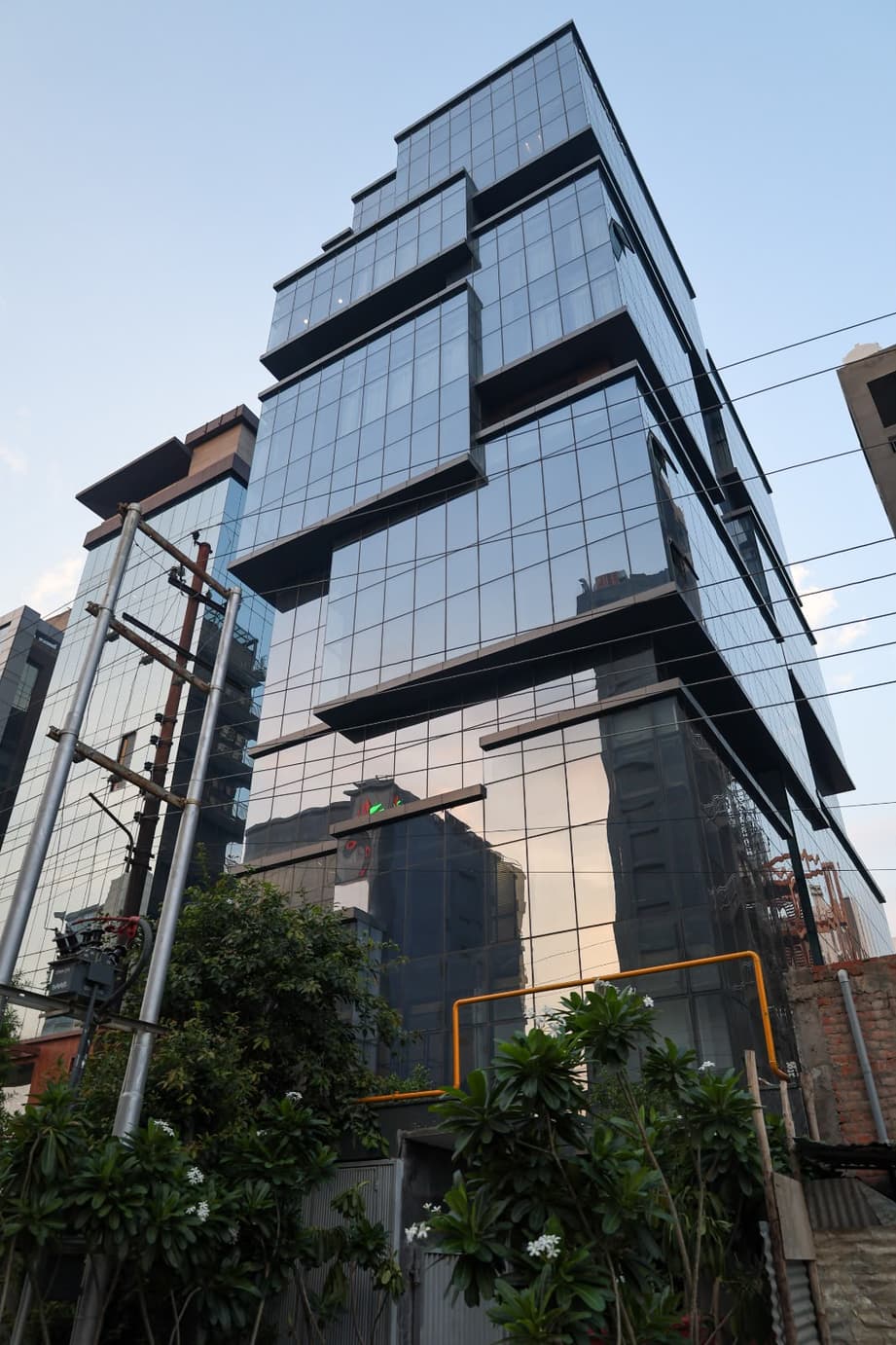 Aquila Grand Suite building exterior, glass-fronted tower with landscaped entrance.