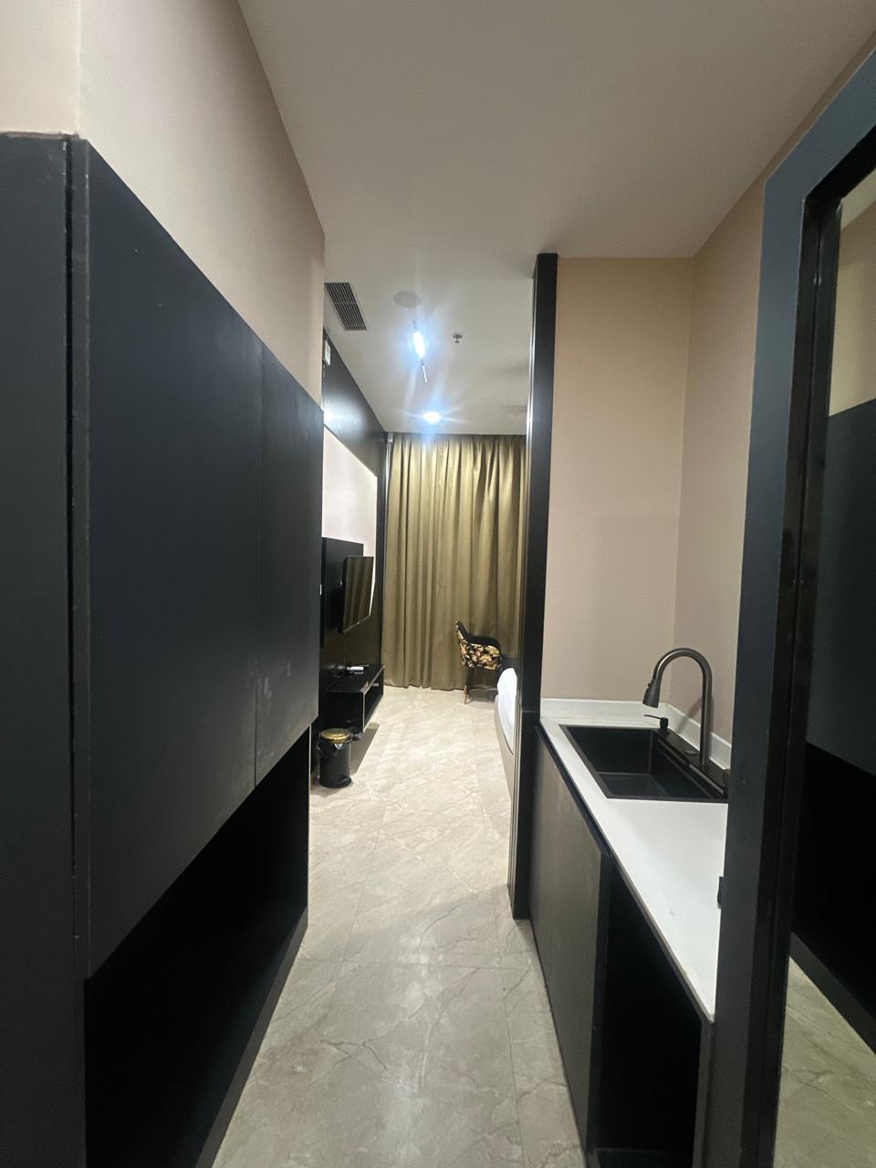 Regal Suite bedroom with a black accent wall and gold silk curtains.